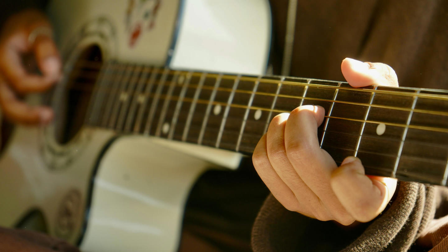 Person playing fingerstyle guitar