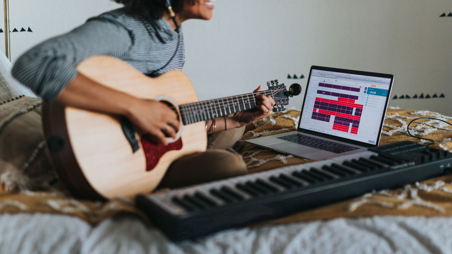 Man in gray t-shirt playing guitar