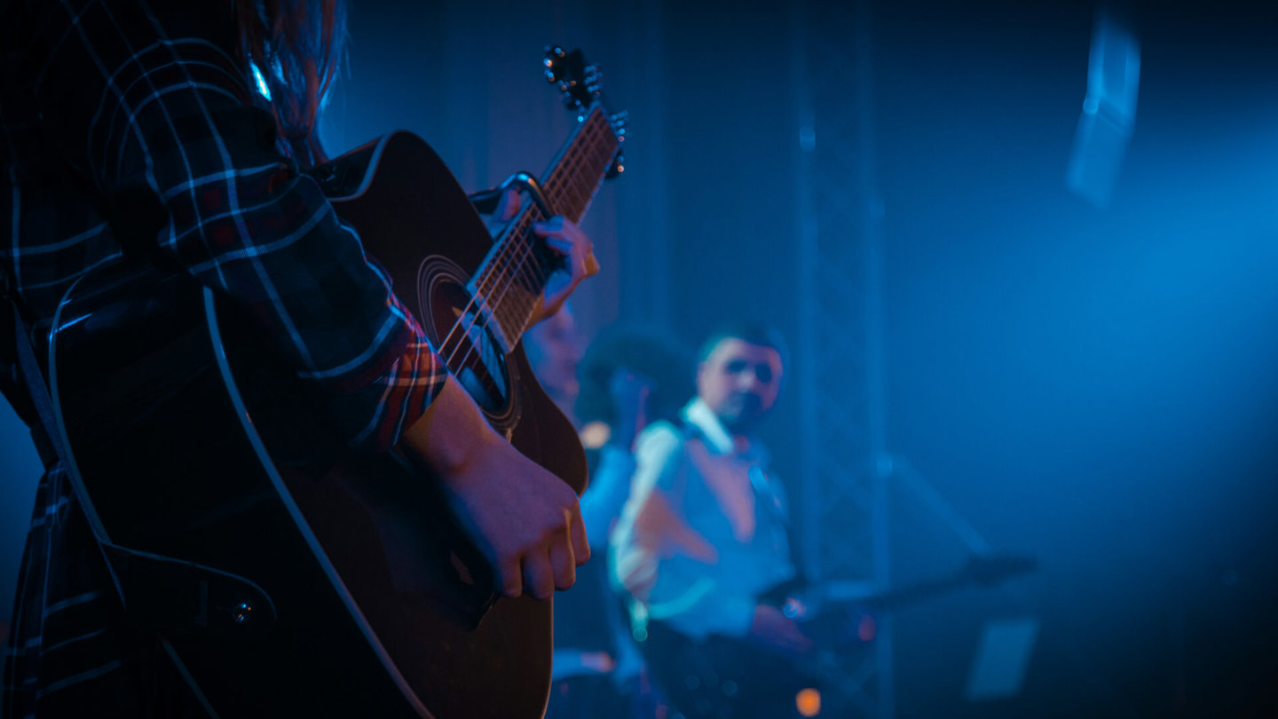 Zwei Personen spielen auf der Bühne Gitarre